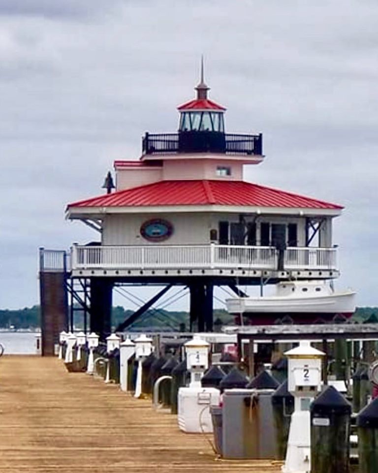 a red and white lighthouse sitting on top of a pier